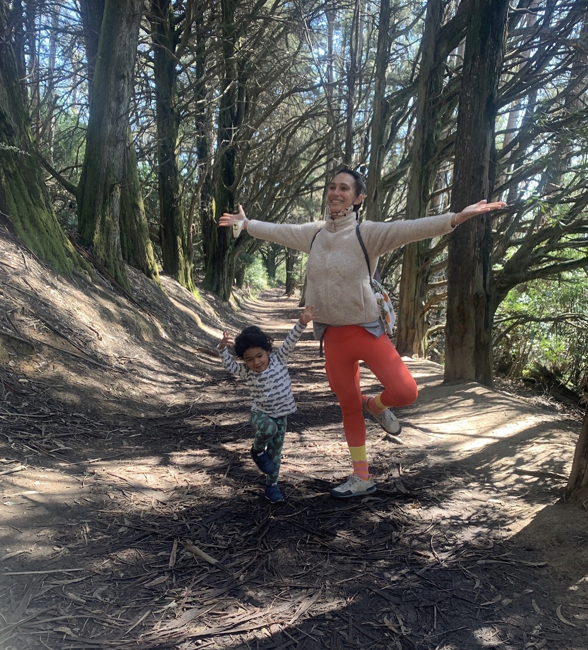 Nadya and her child balancing together on a forest path